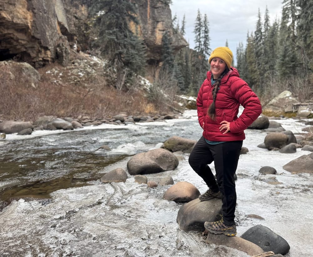 a hiker wearing the patagonia nano-air bottoms on a cold weather hike along an icy river in the southwest