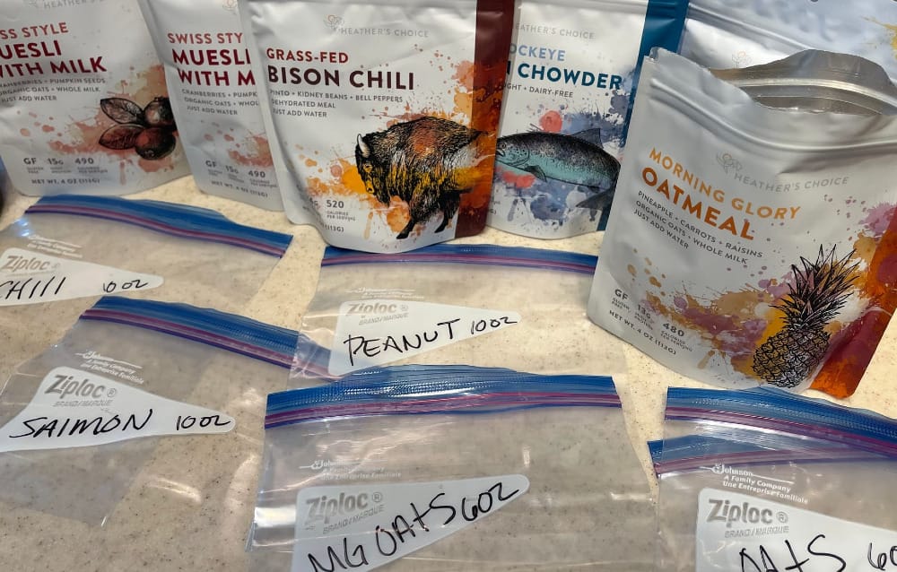 an ultralight backpacker repackages dehydrated meals into ziploc bags in order to cut down on overall pack weight