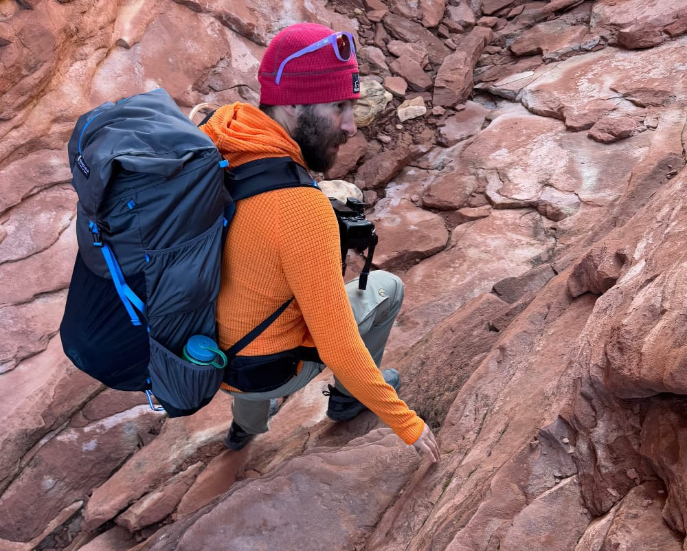 a backpacker wears gossamer gear's mariposa 60 ultralight backpack in a slot canyon of the southwest