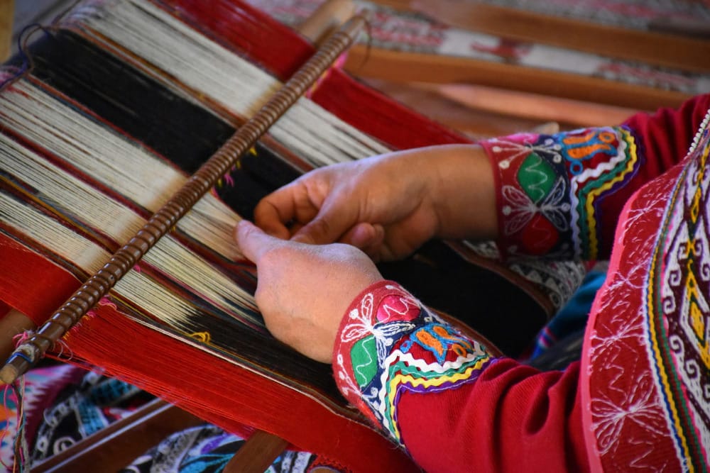 a peruvian woman weaving alpaca wool