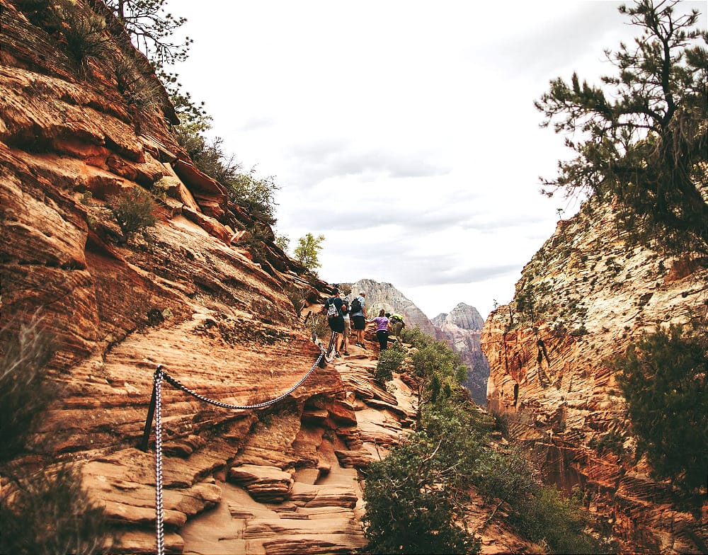 the chain section of angels landing with people hiking it on a bright day in utah's zion national park