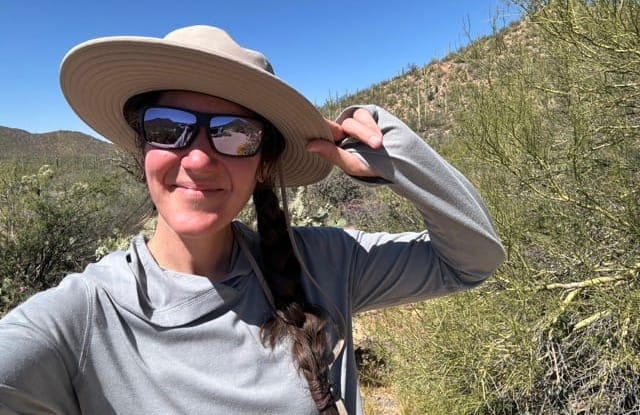 a hiker wears a protective sun hat in the extreme heat of day