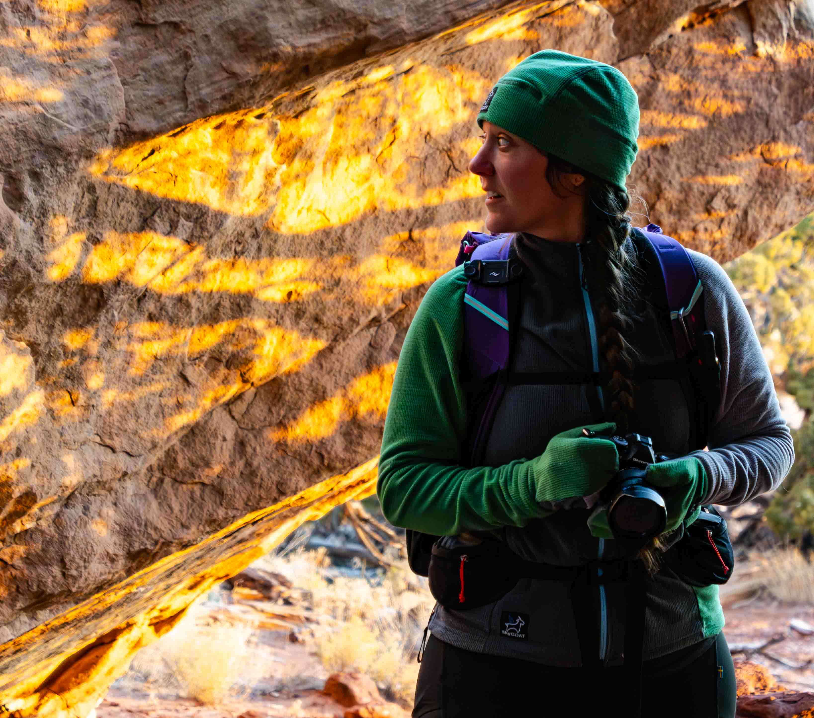 a hiker photographs in a wash of the southwest while wearing the skygoat camp grid fleece jacket to stay warm