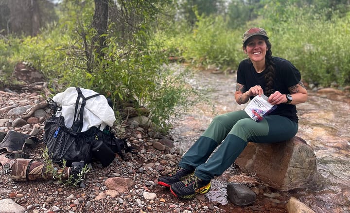 a backpacker and her Hyperlite Mountain Gear Southwest 70 Ultralight Backpack along a southwest cree