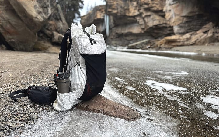 outdoor vitals CS40 Ultra Backpack sitting by an icy river in the southwest loaded up for backpacking through the mountains