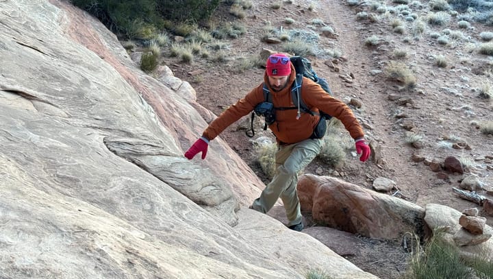 an ultralight backpacker heads up a steep section of slick rock, happy to hae minimal gear and a lightweight setup!