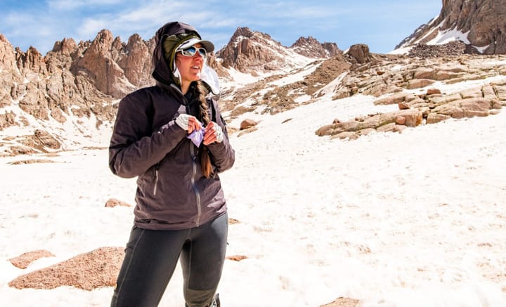 a woman wears a pair of the best hiking pants of 2025 in a mountain basin on an epic hike