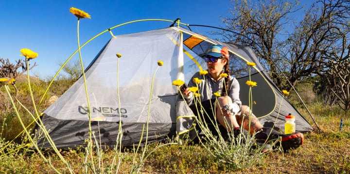 a backpacker sits in the Hornet OSMO Ultralight Backpacking Tent By NEMO Equipment sending off a satelite message